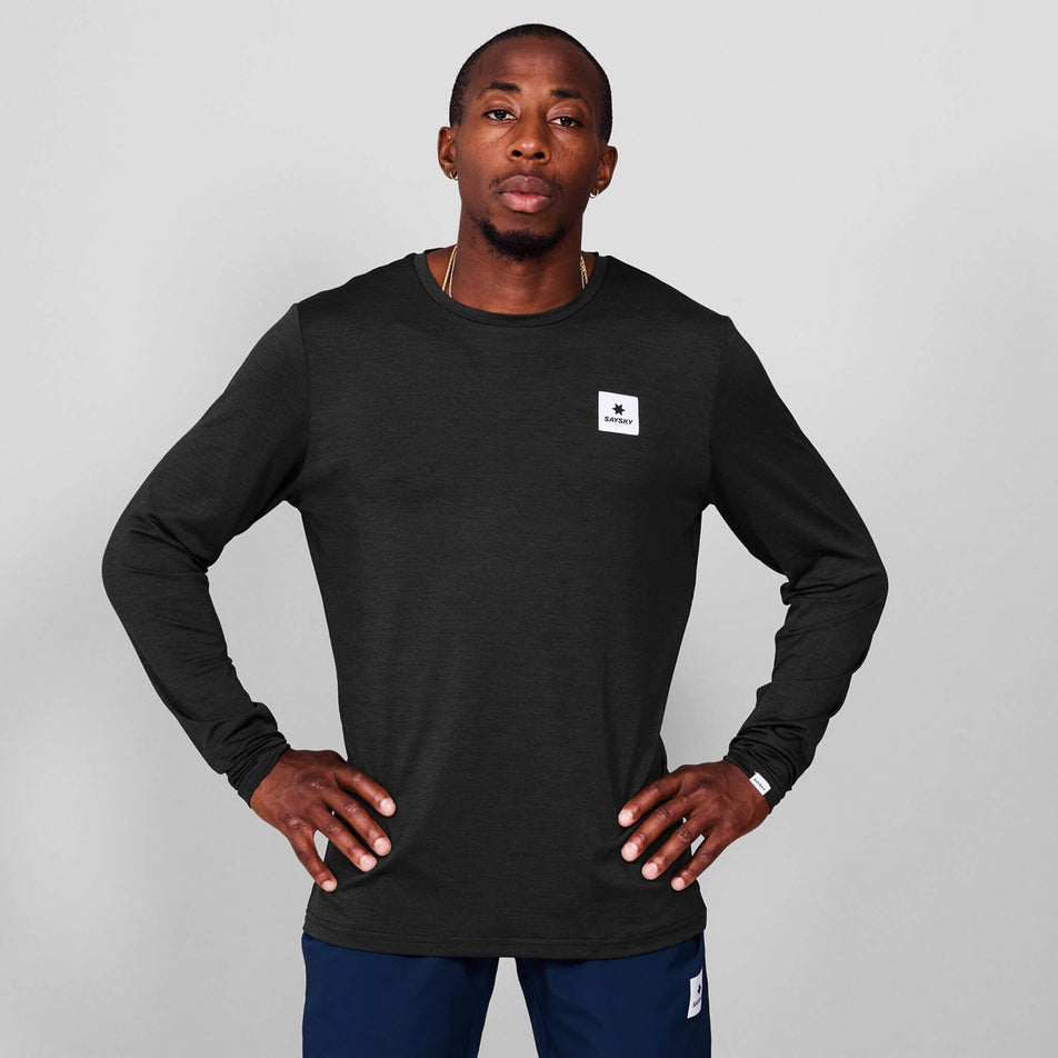 Front view of a model wearing the SAYSKY Men's Clean Pace Long Sleeve in the Black colourway. Model is also wearing tights. (8601315442850)