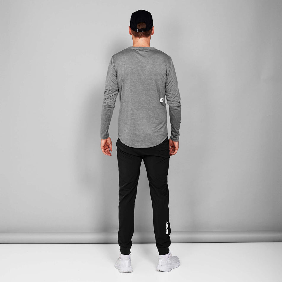 Back view of a model wearing the SAYSKY Unisex Pace Pants in the Black colourway. Model is also wearing a cap, top, socks and shoes. (8602035814562)