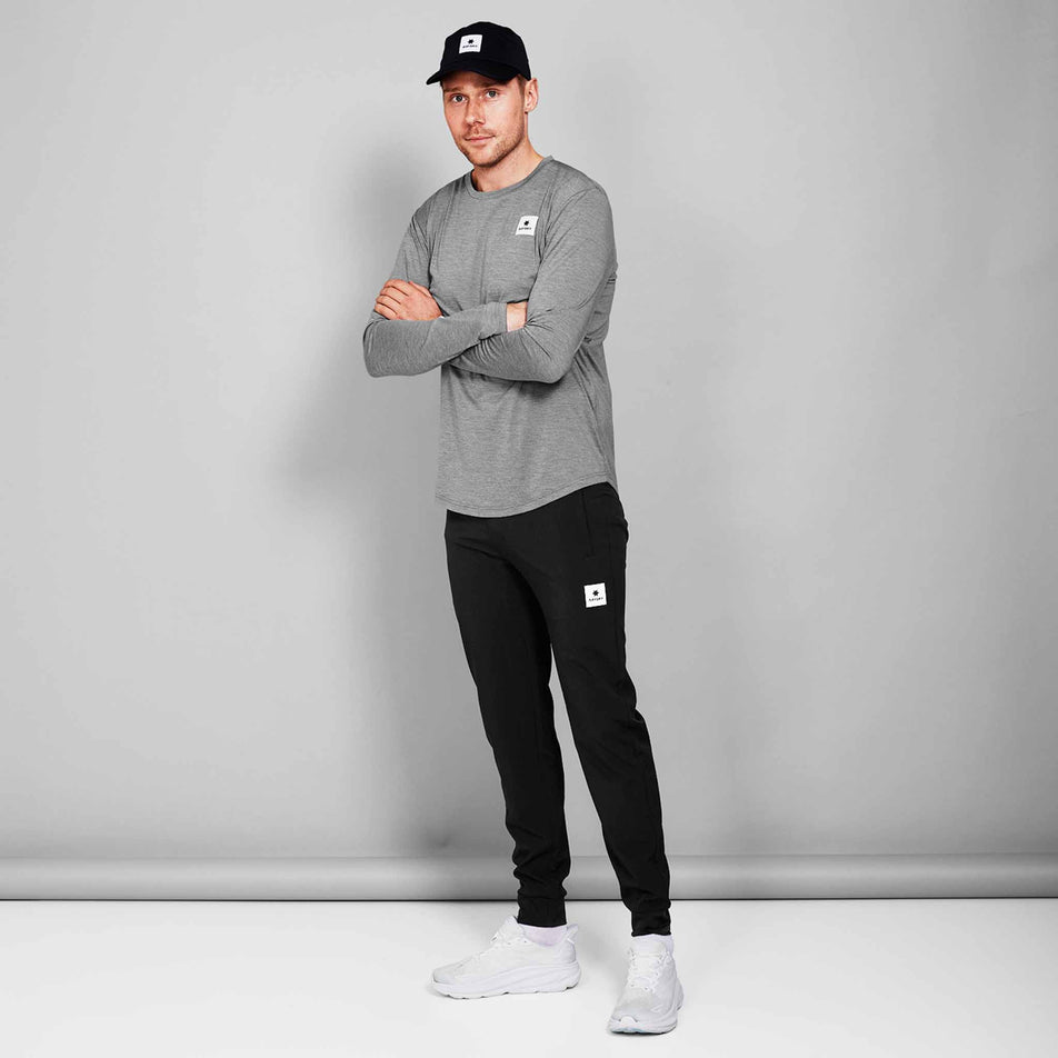 Front view of a model wearing the SAYSKY Unisex Pace Pants in the Black colourway. Model is also wearing a cap, top, socks and shoes. (8602035814562)