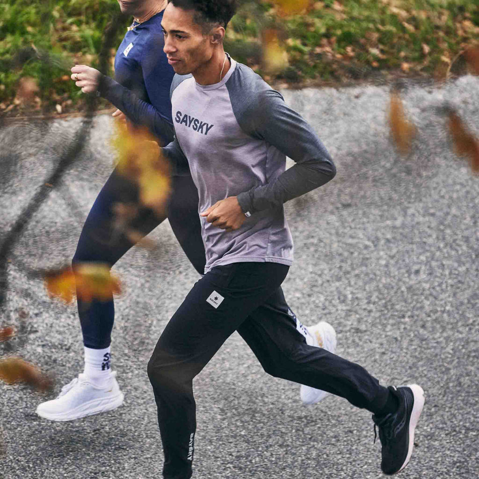 Two people running. One of the runners is wearing the SAYSKY Unisex Pace Pants in the Black colourway. (8602035814562)