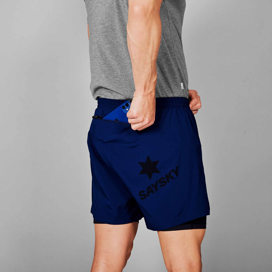 A model demonstrating that a phone can be stored in the zipped back pocket of the SAYSKY Men's 2 In 1 Pace Shorts 5