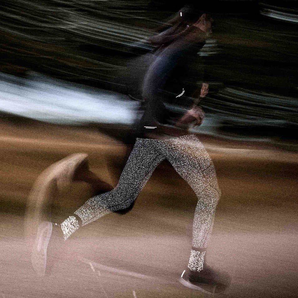 A model running in a pair of SAYSKY Unisex Combat Reflective High Socks in the Black colourway. (8788287291554)