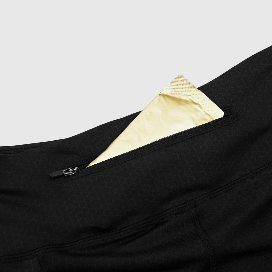 An energy gel sticking out of the back zip pocket of a pair of SAYSKY Women's Combat+ Short Tights 7