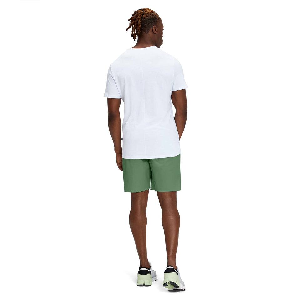 Back view of a model wearing a pair of men's On Hybrid Shorts in the ivy colour (7763890536610)