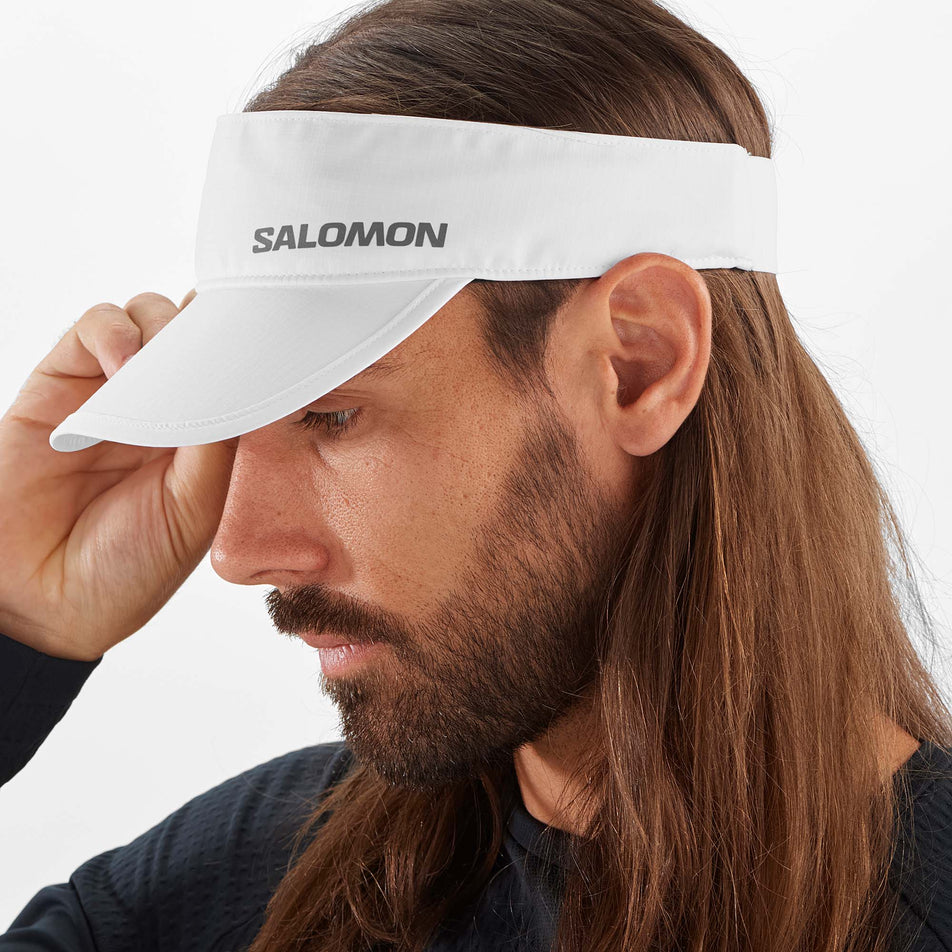 Side male model view of Salomon Unisex Cross Running Visor in white. (7777955578018)