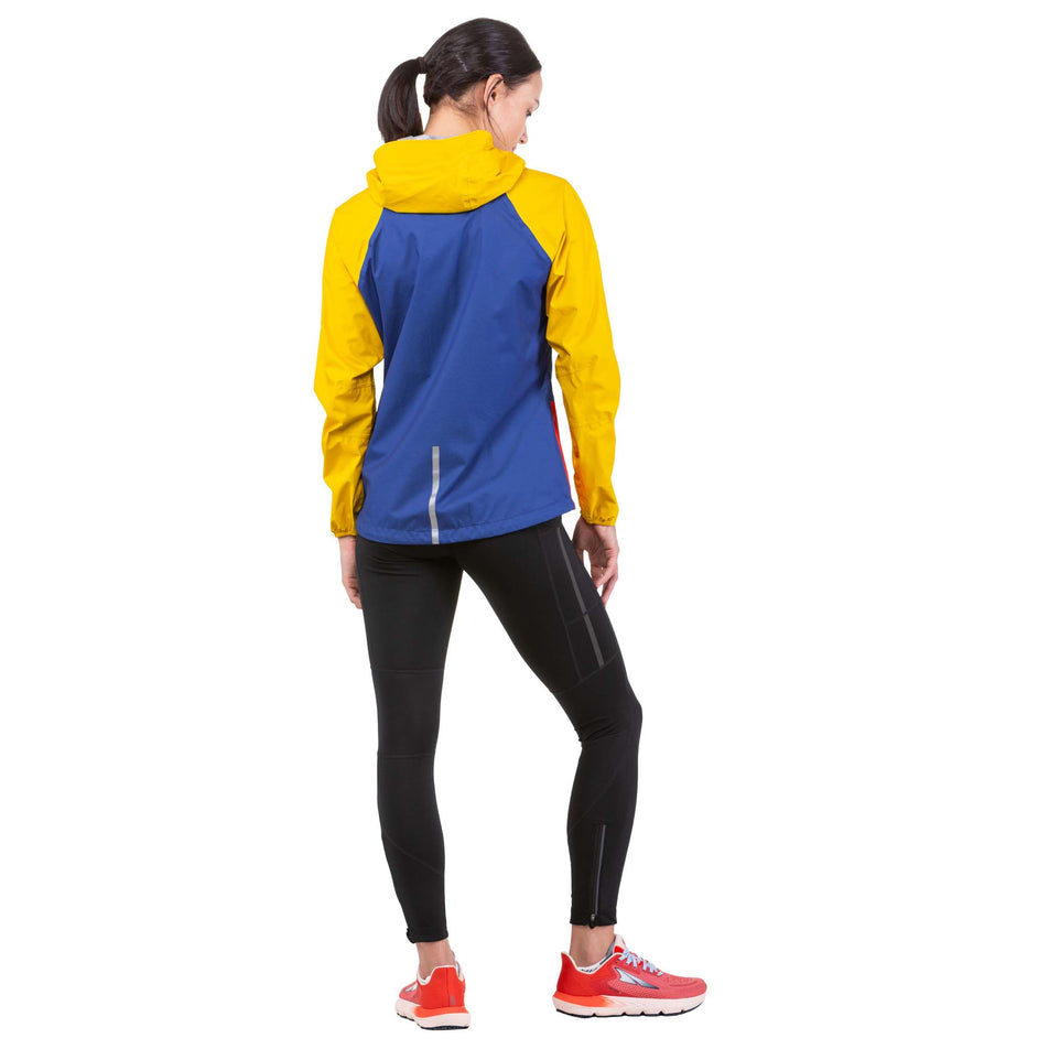 Back view of a model wearing a Ronhill Women's Tech Fortify Jacket in the Dark Cobalt/Solar colourway (7746201976994)