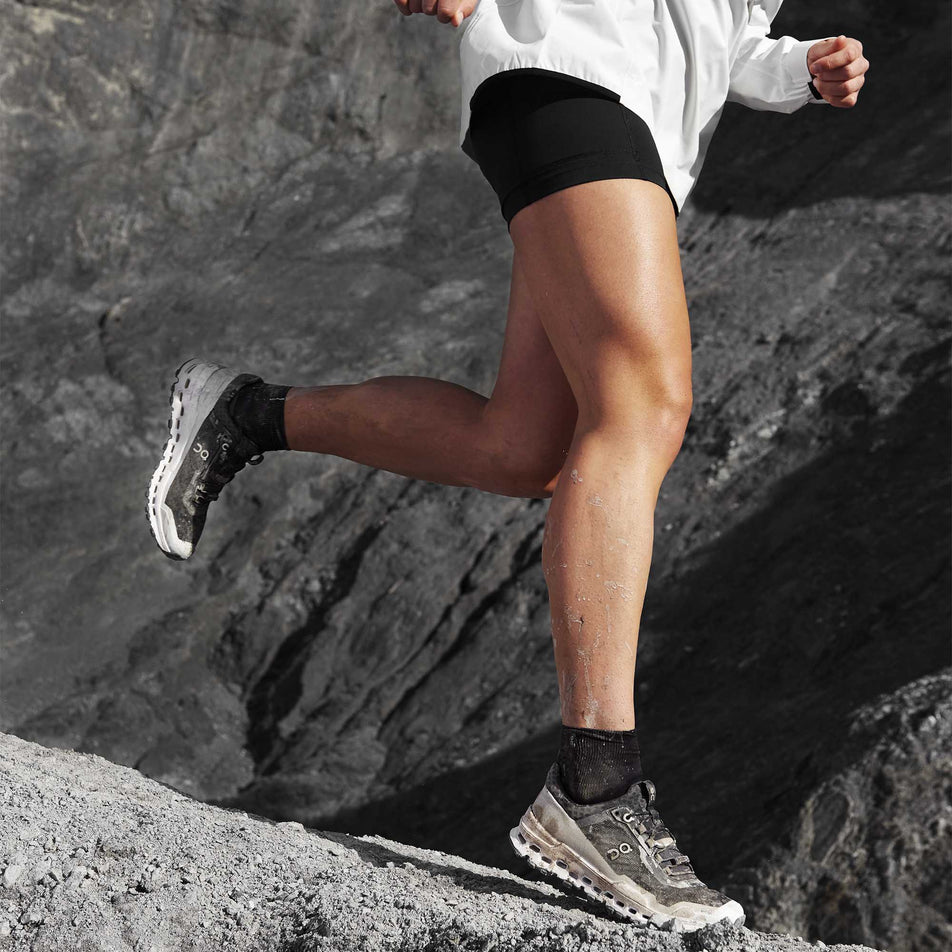 Person running downhill wearing a pair of On Cloudultra running shoes (6888586412194)
