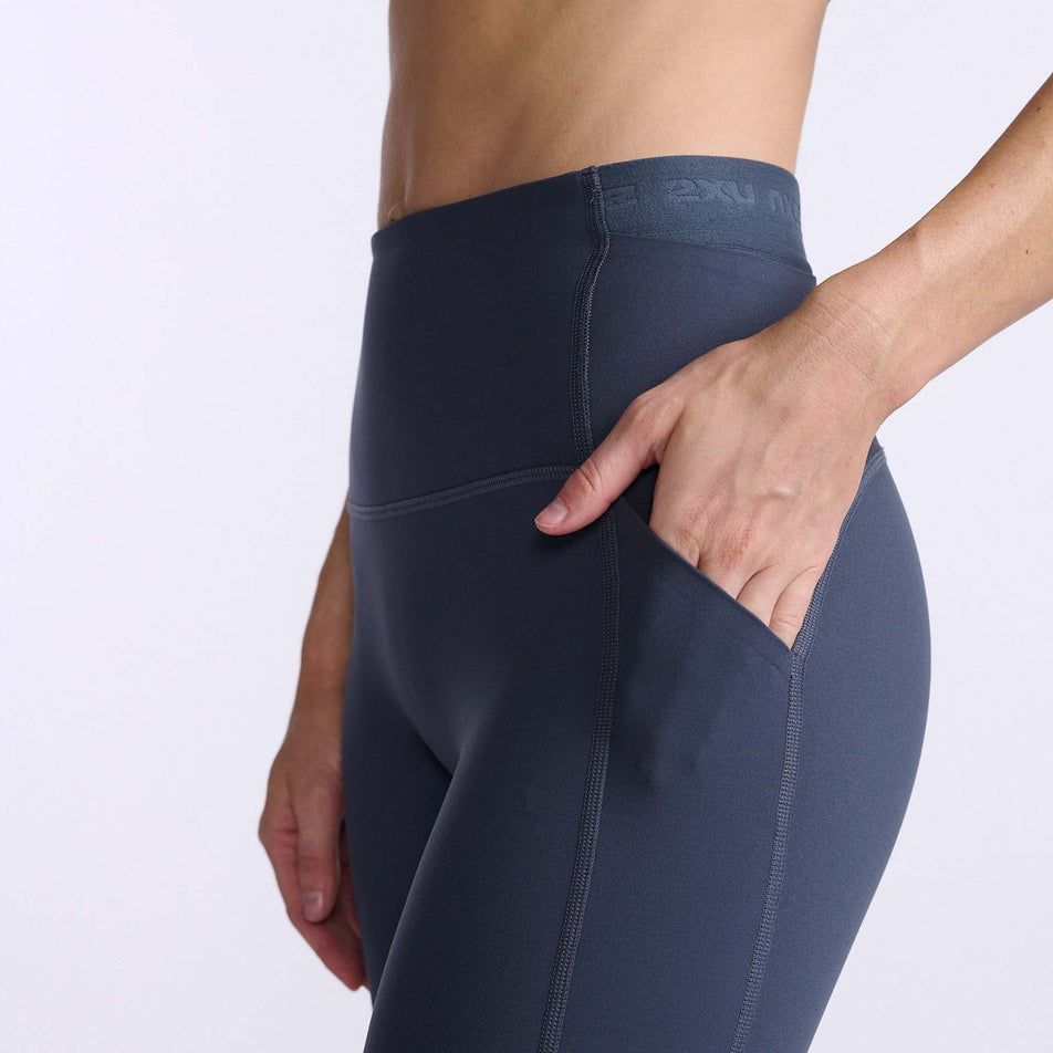 Close-up side view of the upper section of a pair of 2XU  Women's Form Stash Hi-Rise Compression Tights, being worn by a model (7778519842978)