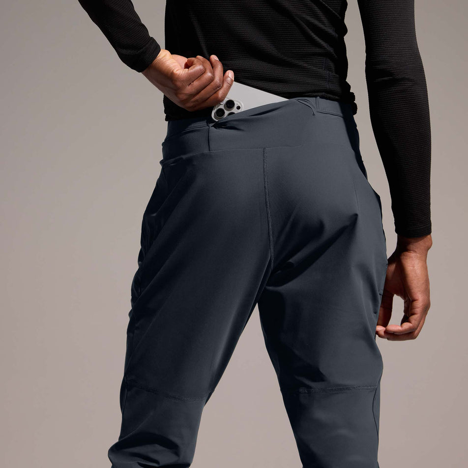 A model demonstrating the pocket on the back of the GOREWEAR Men's Everyday Track Pants in the Lab Graphite colourway. (8752076423330)