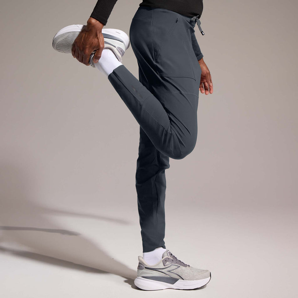 Side view of a model wearing the GOREWEAR Men's Everyday Track Pants in the Lab Graphite colourway. (8752076423330)