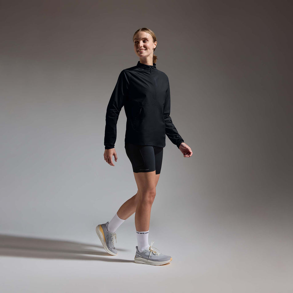 Angled view of a model wearing the GOREWEAR Women's Concurve Windbreaker Anorak in the Black colourway.