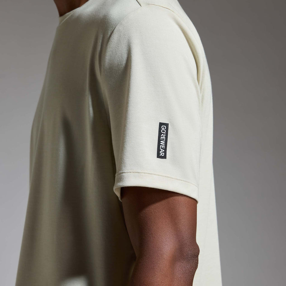 Side view of a model wearing the GOREWEAR Men's Training Tee in the Tech Beige colourway.