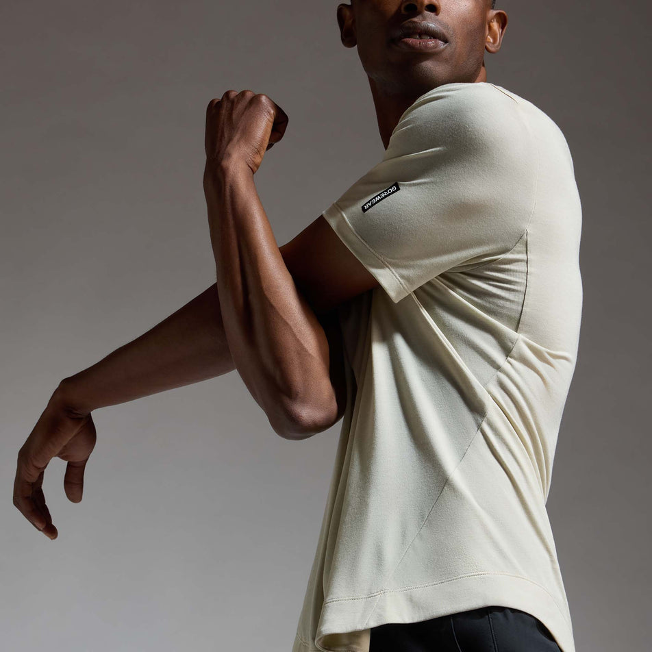 Angled view of a model wearing the GOREWEAR Men's Training Tee in the Tech Beige colourway.