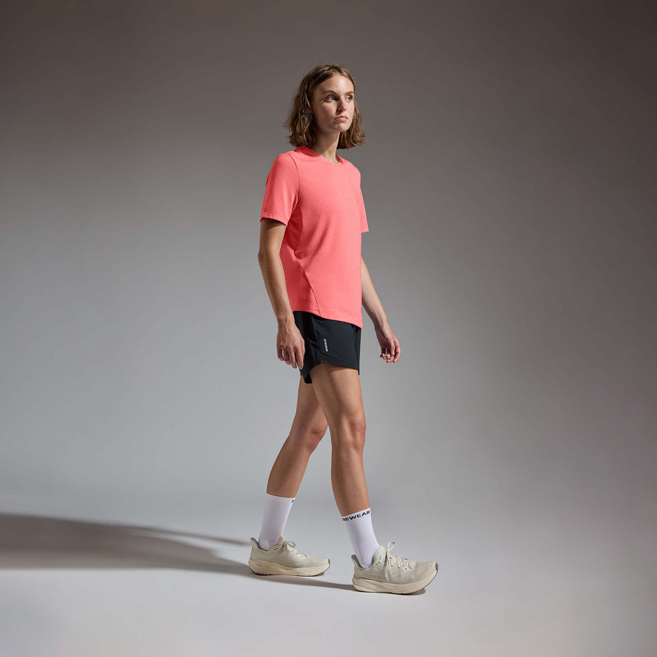 Angled view of a model wearing the GOREWEAR Women's Training Tee in the Coral Red colourway.
