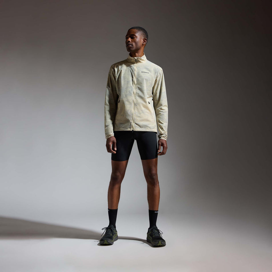 Front view of a model wearing the GOREWEAR Men's Concurve Electro Windbreaker in the Crushed Tech Beige/Lab Gray colourway.