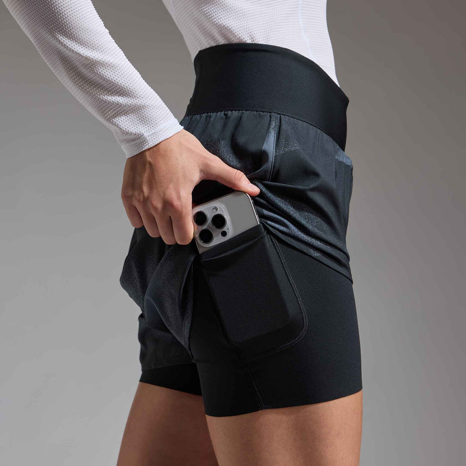 A model demonstrating the drop-in pocket on the GOREWEAR Women's Concurve 3