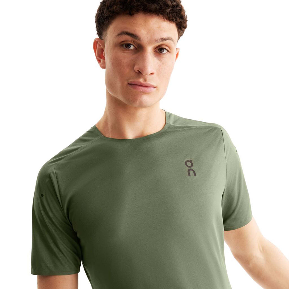 Close-up front view of a model wearing an On Men's Performance T in the Taiqa colourway. Upper half of the t-shirt is visible.  (8004183130274)