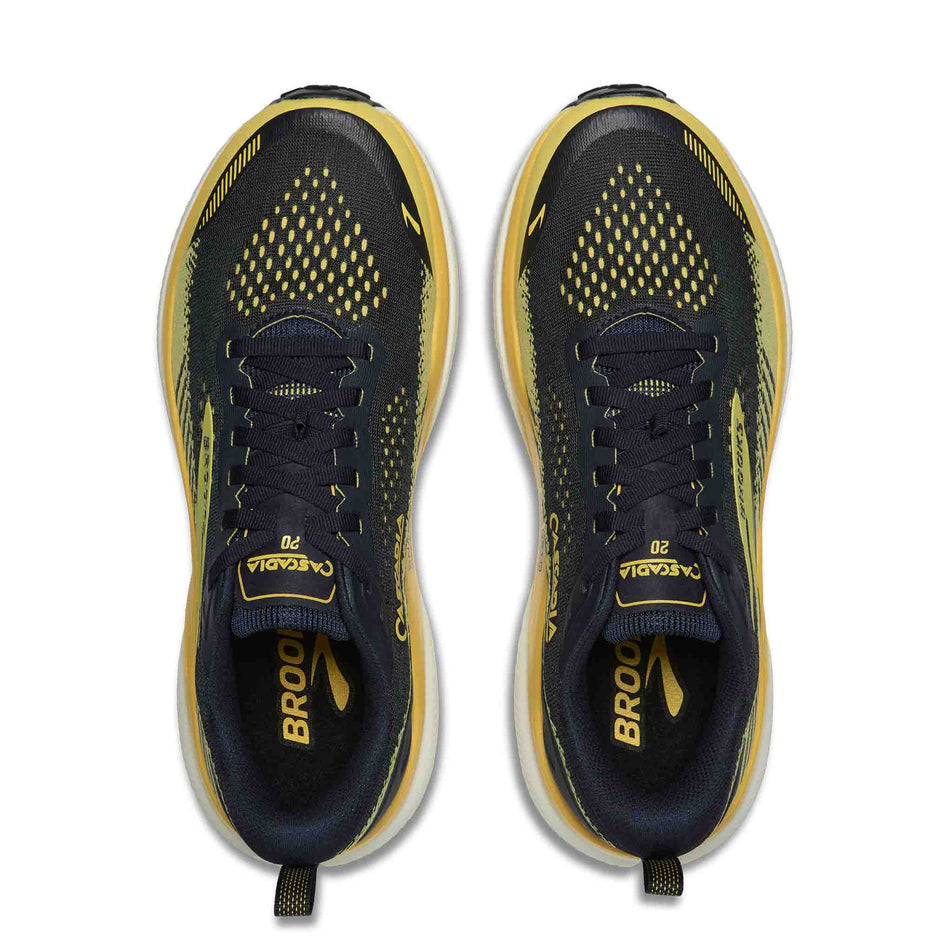 The uppers of a pair of Brooks Men's Cascadia 20 Running Shoes in the Navy/Cyber Yellow/Grey colourway.
