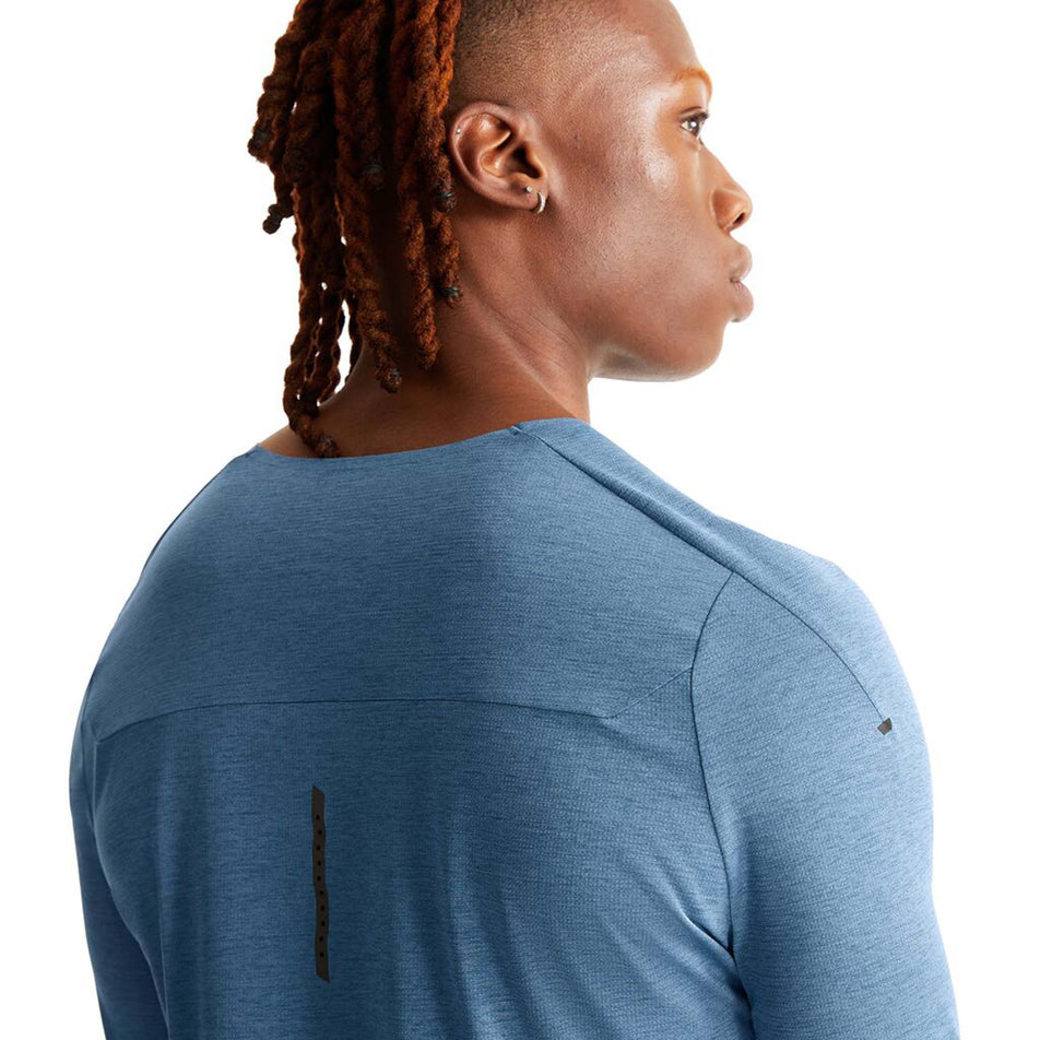 Close-up back view of a model wearing an On Men's Performance Long-T in the Stellar colourway. Upper third of the t-shirt is visible. (8005042995362)