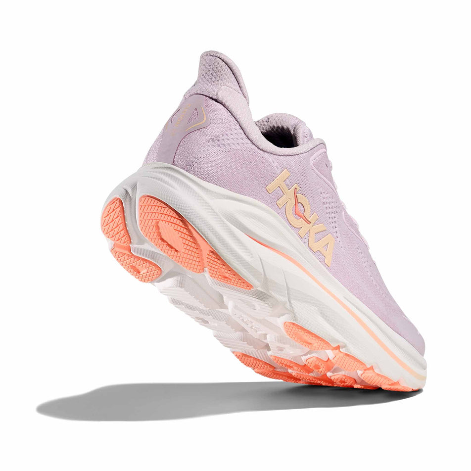 Lateral - and outsole - view of the right shoe from a pair of HOKA Women's Clifton 10 Running Shoes in the Lilac Cream/Tangerine Glow colourway.
