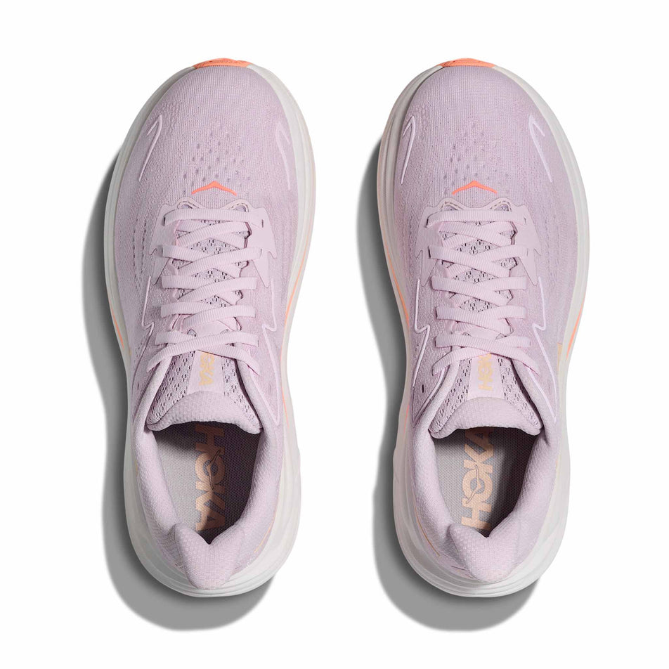 The uppers of a pair of HOKA Women's Clifton 10 Running Shoes in the Lilac Cream/Tangerine Glow colourway.