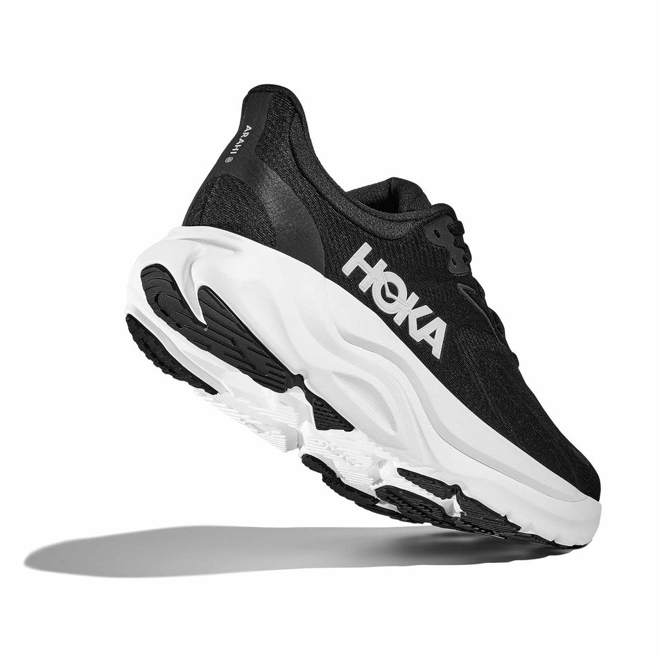 Lateral - and outsole - view of the right shoe from a pair of HOKA Women's Arahi 8 Running Shoes in the Black/White colourway.