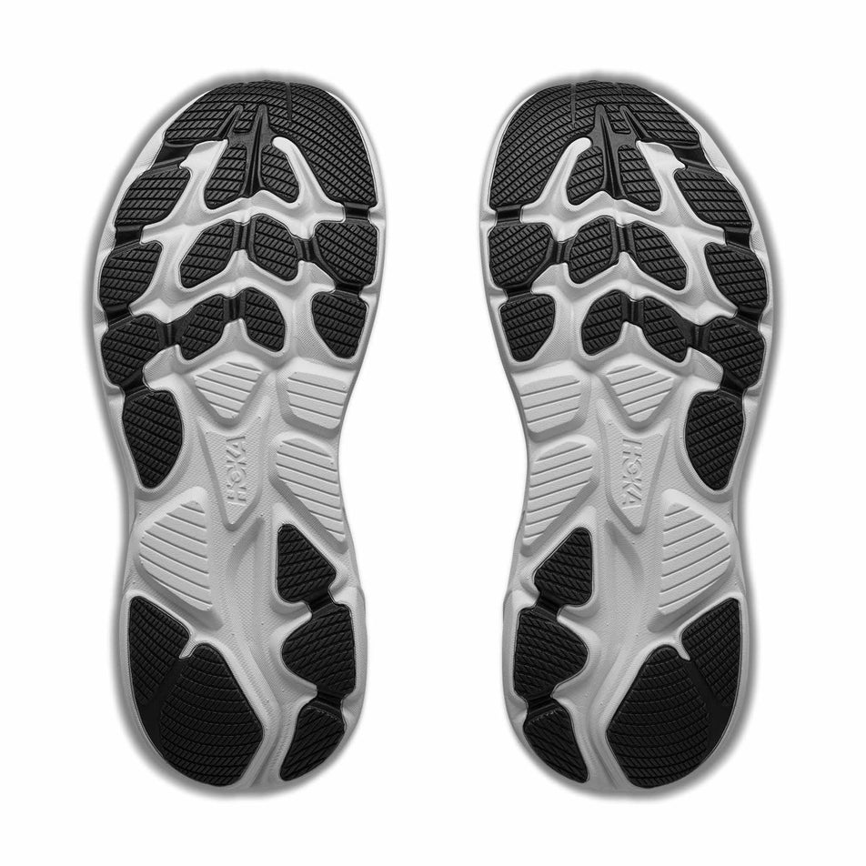The outsoles of a pair of HOKA Clifton 10 Big Kids Running Shoes in the Black/Cosmic Grey colourway.