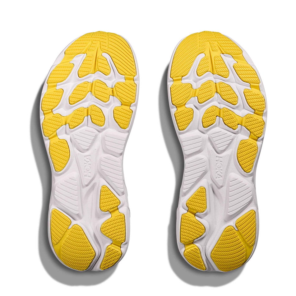 The outsoles of a pair of HOKA Clifton 10 Big Kids Running Shoes in the Frost/Soaring Blue colourway.