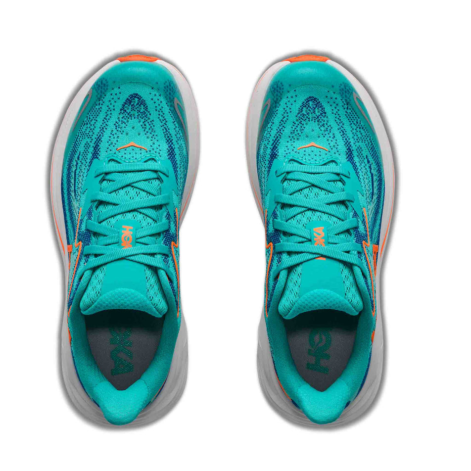 The uppers of a pair of HOKA Clifton 10 Big Kids Running Shoes in the Night Glow Blue/Electric Aqua colourway.