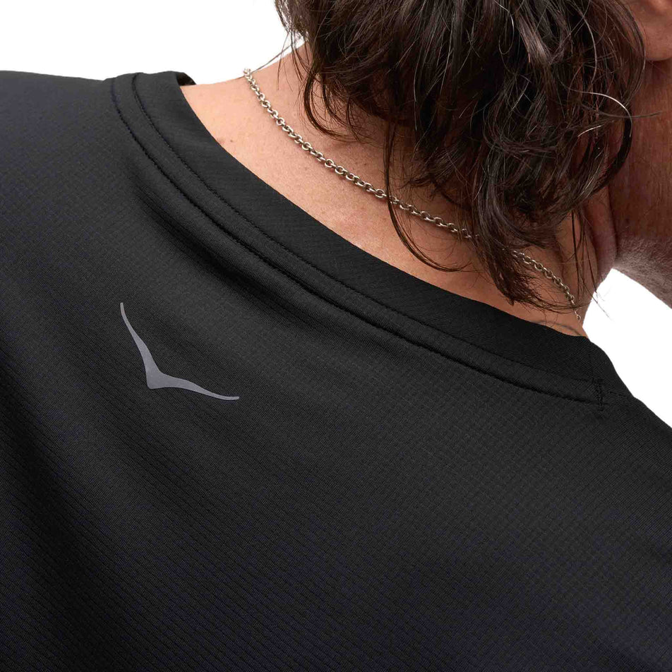 Back view of a model wearing the HOKA Men's Everyrun Short Sleeve in the Black colourway.