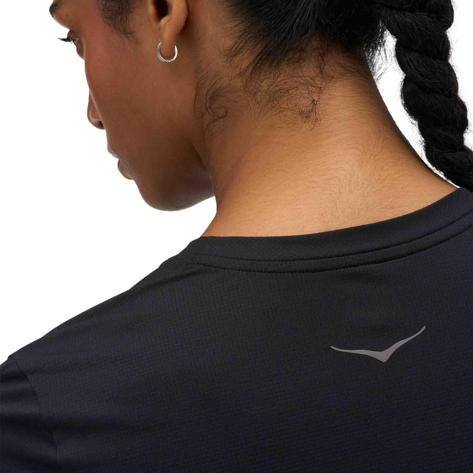 Back view of a model wearing the HOKA Women's Everyrun Short Sleeve in the Black colourway.