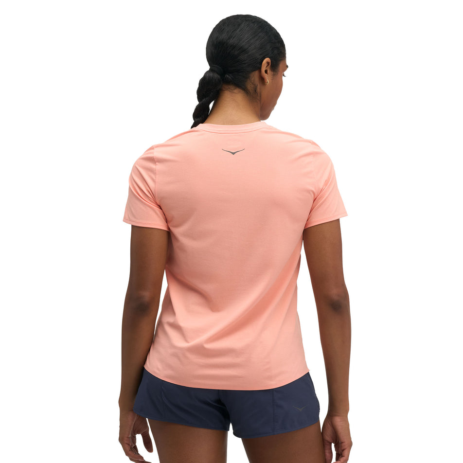 Back view of a model wearing the HOKA Women's Everyrun Short Sleeve in the Sunstone colourway.
