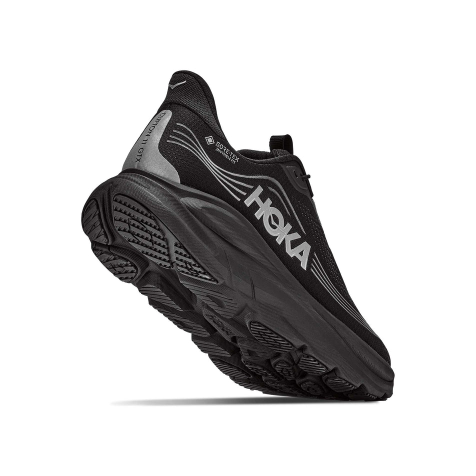 Lateral - and outsole - view of the right shoe from a pair of HOKA Women's Clifton 11 GTX Running Shoes in the Black/Black colourway.