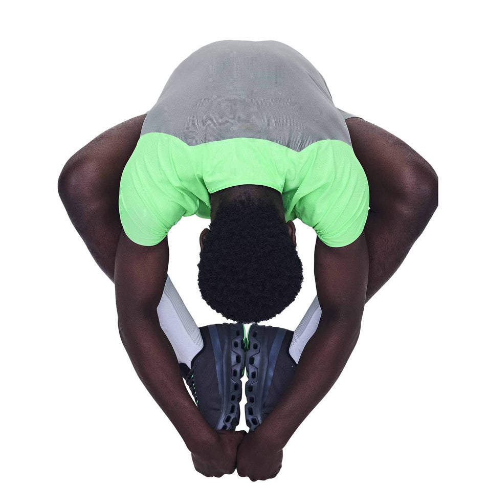 Angled view of a model wearing the On Men's Performance-T in the Verdite/Apollo colourway.