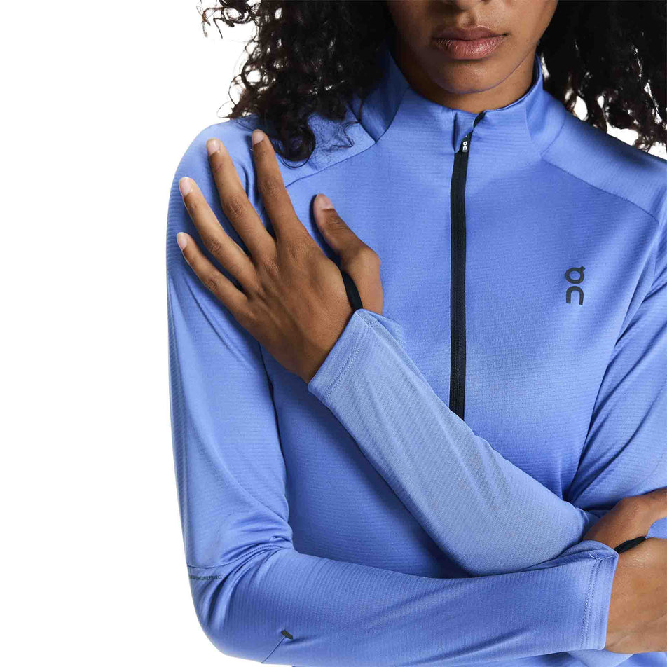 A model demonstrating the thumbloops on the On Women's Climate Shirt in the Sailor colourway.