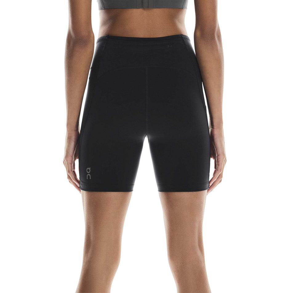 Back view of a model wearing the On Women's Performance Tights Short in the Black colourway. (8715718197410)