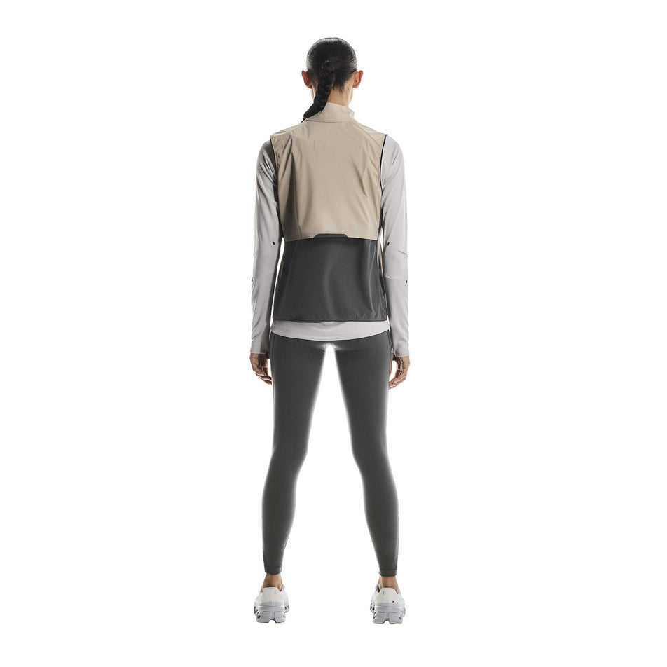Back view of a model wearing the On Women's Weather Vest in the Desert/Eclipse colourway. (8790011412642)