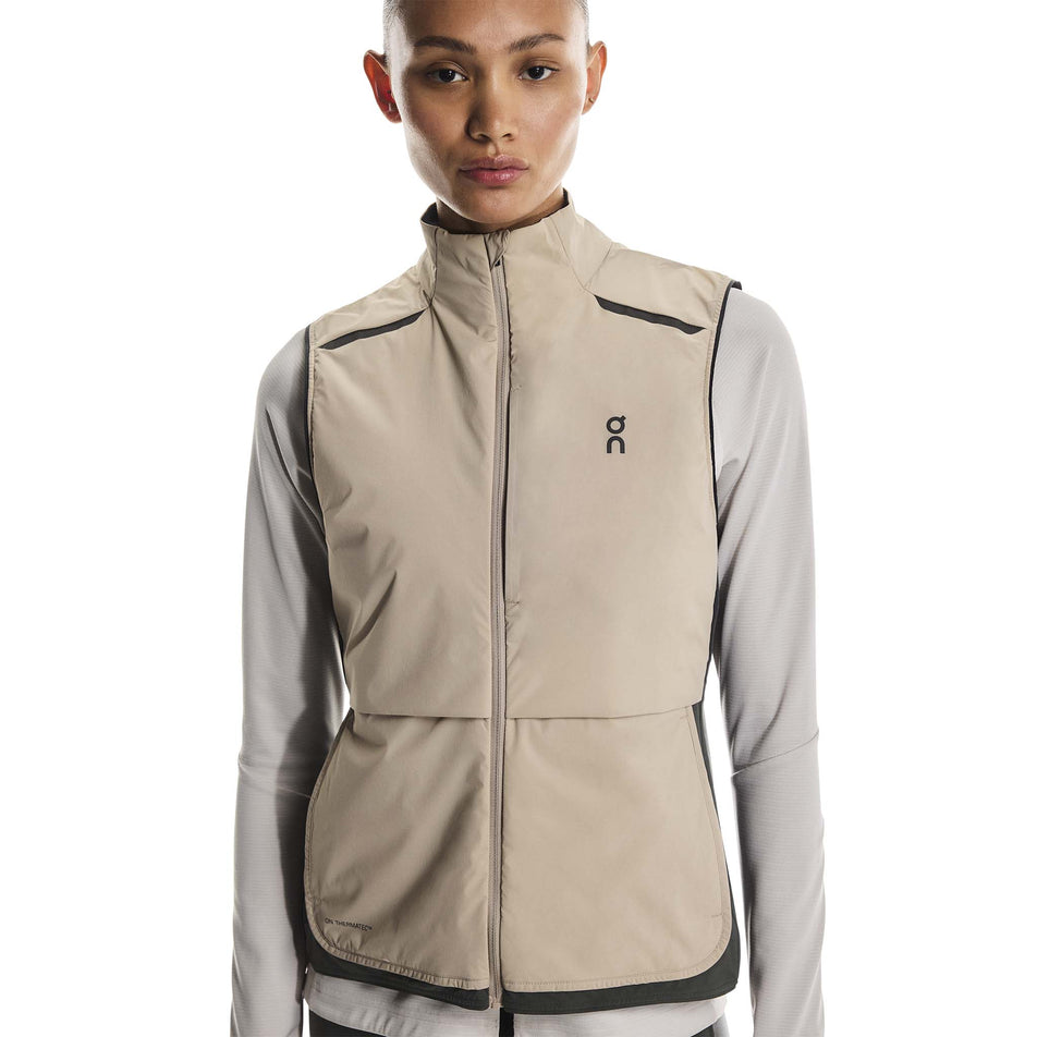Front view of a model wearing the On Women's Weather Vest in the Desert/Eclipse colourway. (8790011412642)