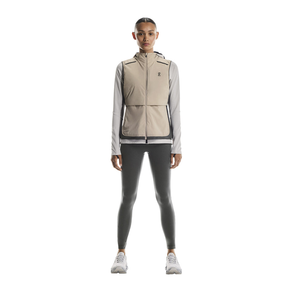 Front view of a model wearing the On Women's Weather Vest in the Desert/Eclipse colourway. (8790011412642)