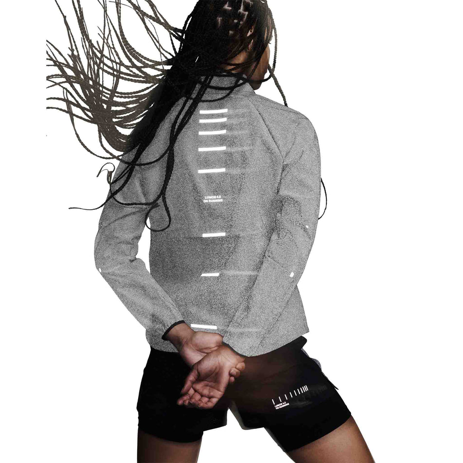 Back view of a model wearing the On Women's Weather Jacket Lumos in the Eclipse colourway. (8790034808994)