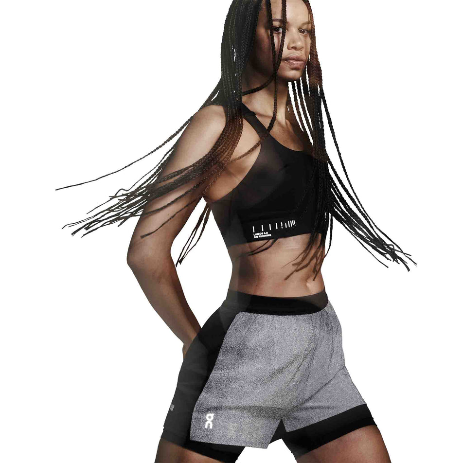 The reflective detail on the On Women's Performance Shorts Lumos in the Eclipse/Black colourway. (8790051815586)