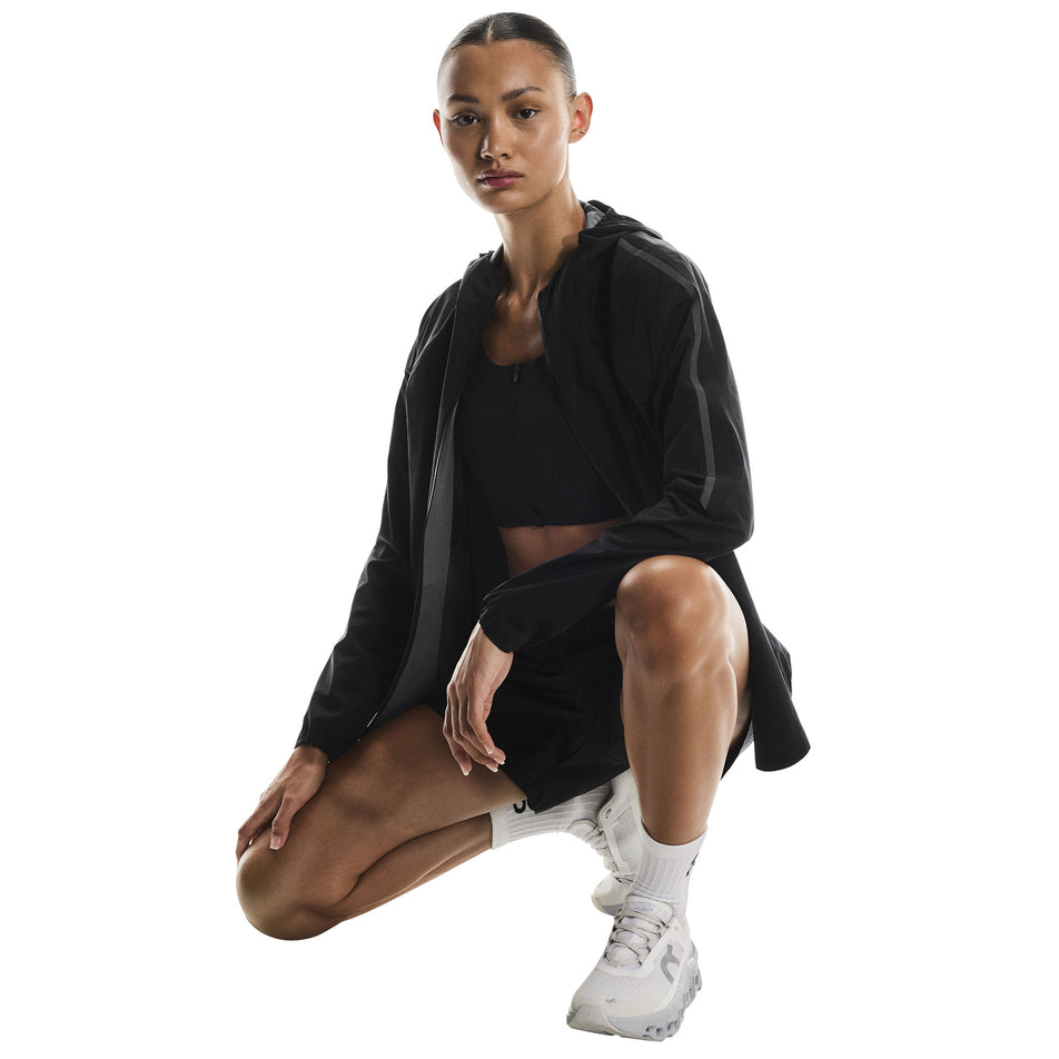 Front view of a model wearing the On Women's Performance Waterproof Jacket in the Black colourway. (8790002696354)