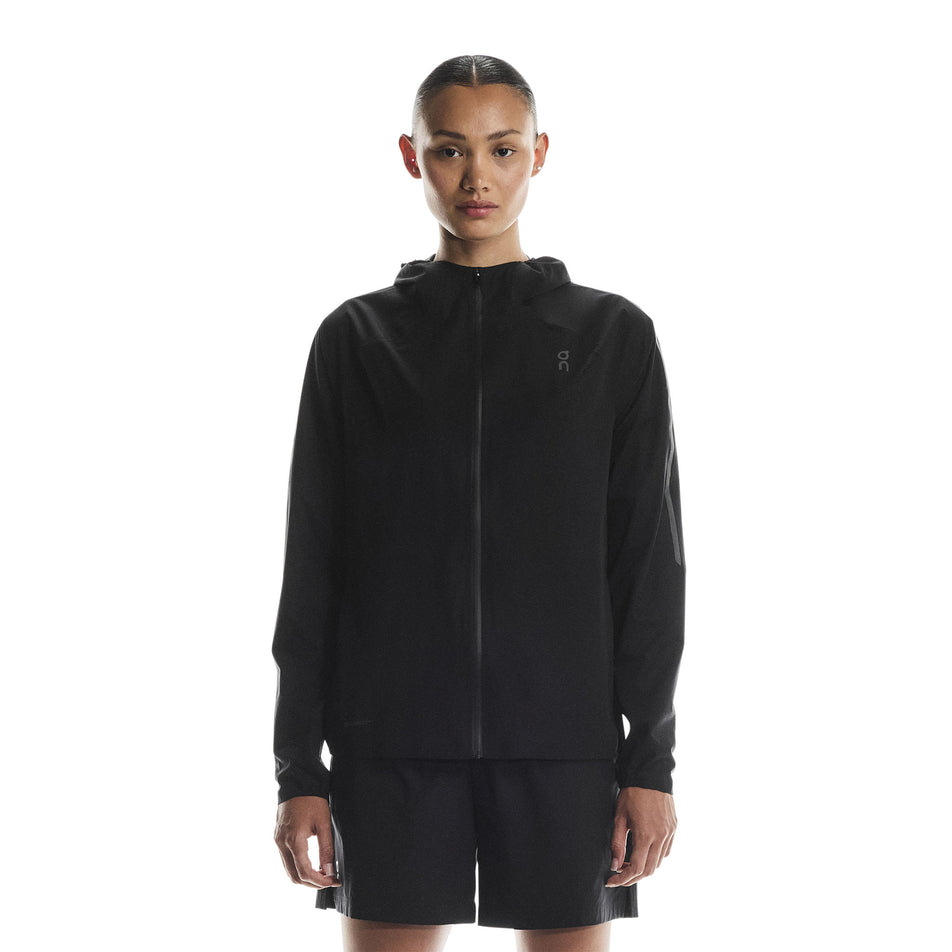 Front view of a model wearing the On Women's Performance Waterproof Jacket in the Black colourway. (8790002696354)