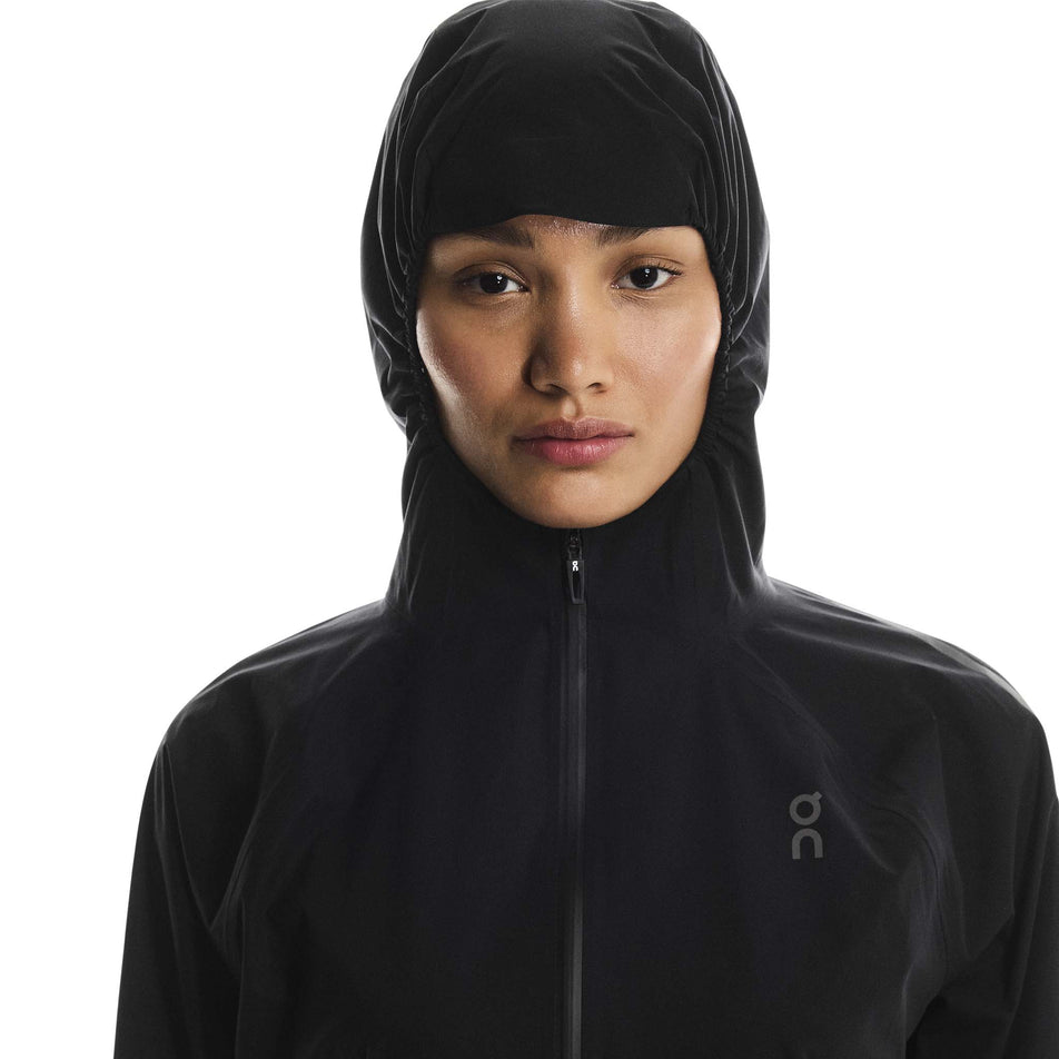 Front view of a model wearing the On Women's Performance Waterproof Jacket in the Black colourway. (8790002696354)