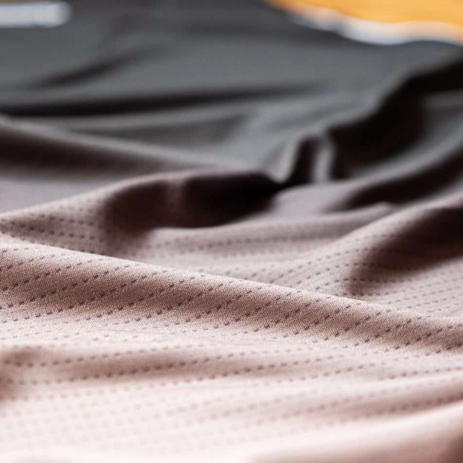 Close-up view of the fabric of the EMF Official Licensed Merchandise | Pressio Men's Prevail Singlet in the Black/Stone colourway.