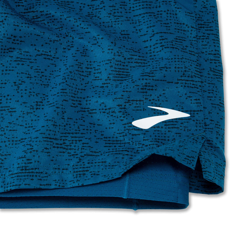 Close-up front view of the lower left-side of a pair of Brooks Men's Sherpa 7 Inch 2-in-1 Shorts in the Dark Ocean Terrain Print colourway. The Brooks logo is visible.  (8007477133474)
