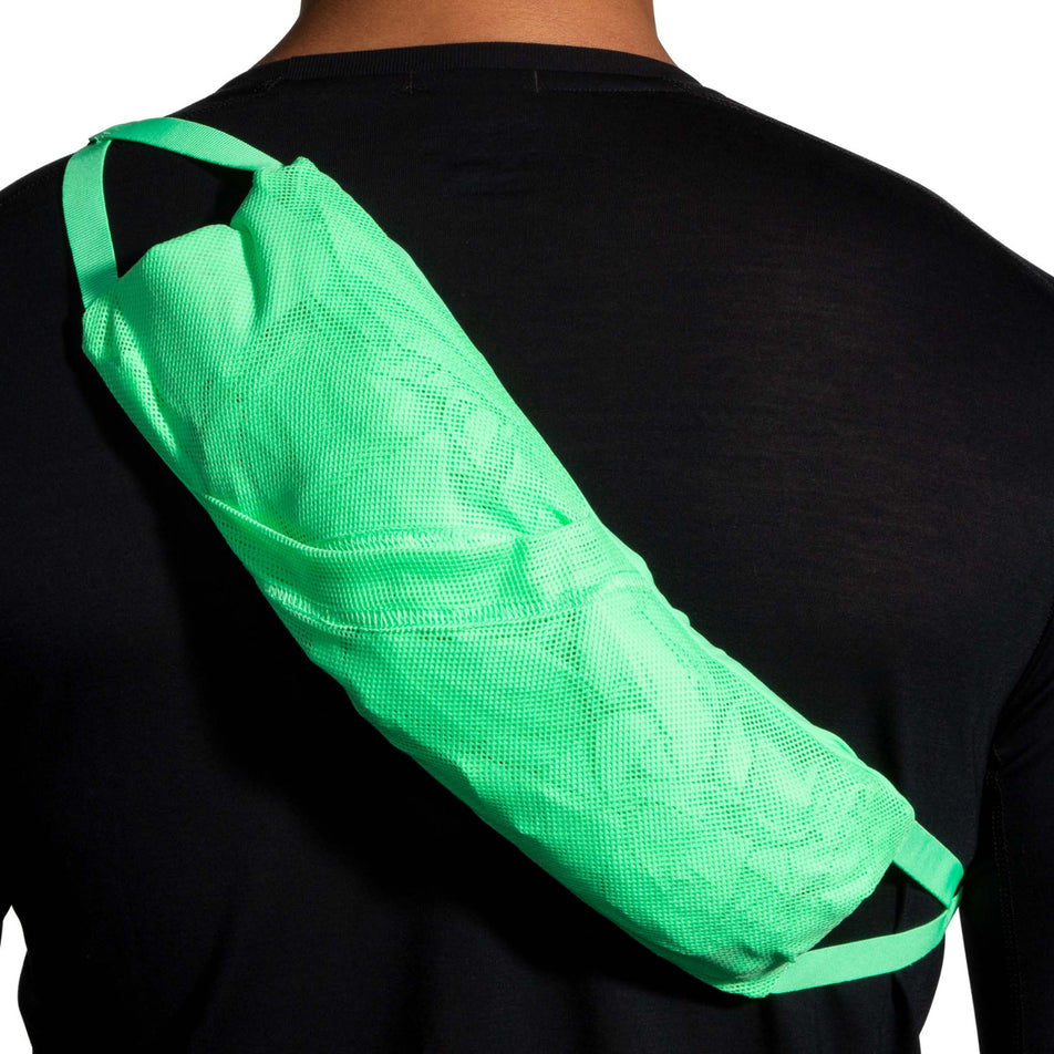 A model demonstrating that the Brooks Men's Canopy Jacket, in the Neo Green colourway, can be rolled up and worn over one shoulder and under the other shoulder.  (8007418314914)