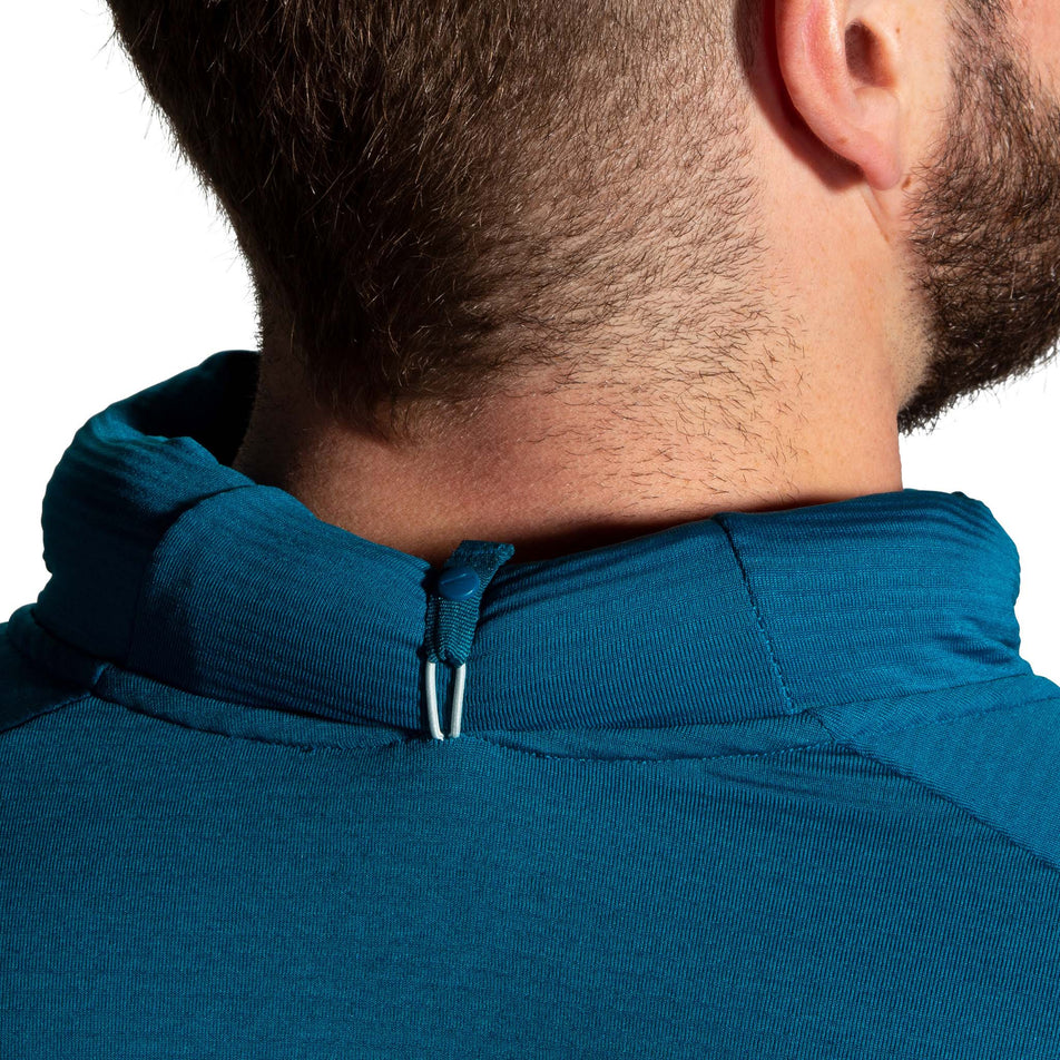 Back view of model wearing a Brooks Men's Notch Thermal Hoodie 2.0 in the Heather Dark Ocean/Dark Ocean colourway, demonstrating that the hood can be rolled up and secured in place.  (8007425589410)