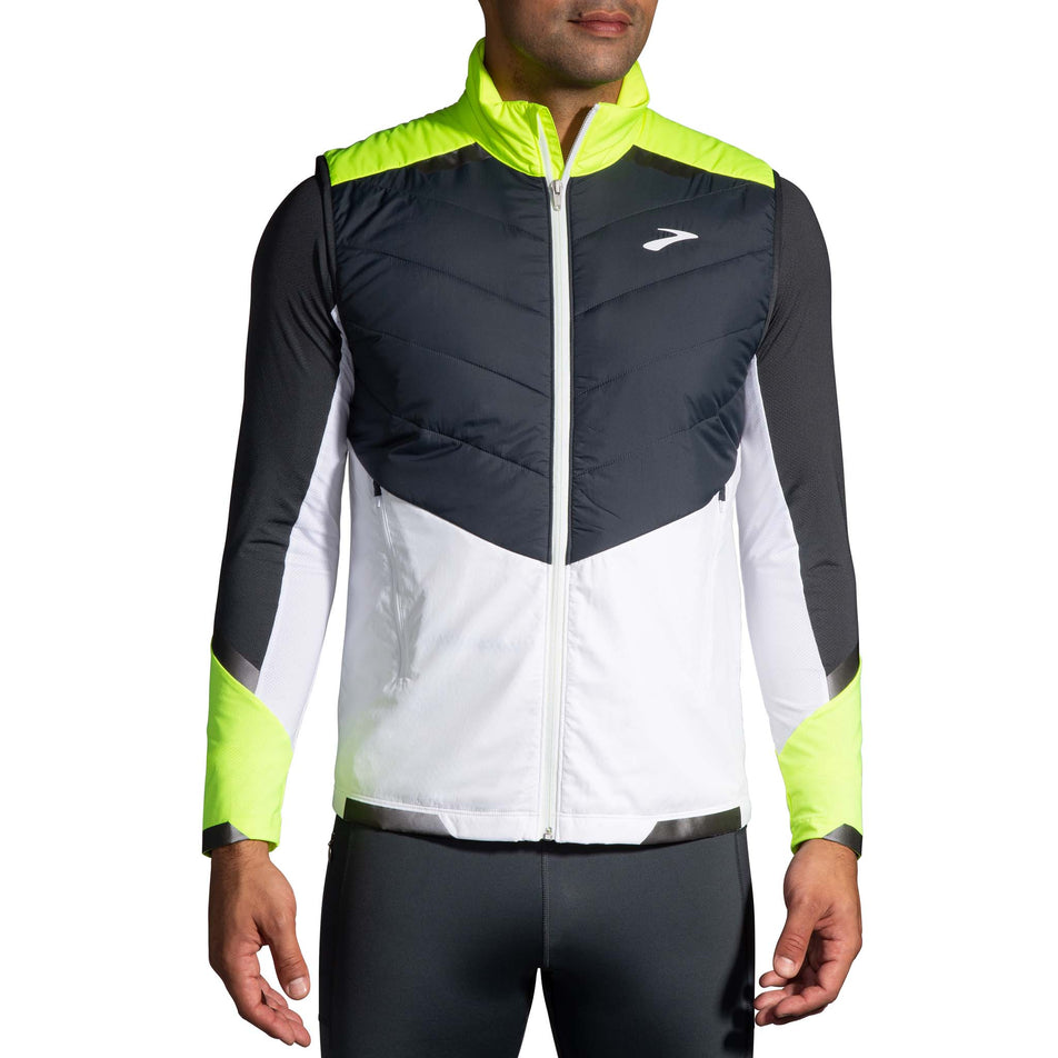 Front view of model wearing a Brooks Men's Run Visible Insulated Vest in the White/Asphalt/Nightlife colourway. Model is wearing also wearing a Brooks long sleeve top.  (8059815329954)