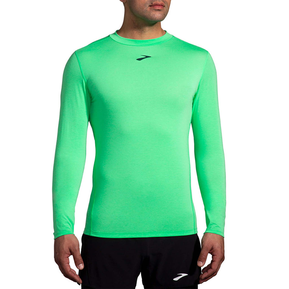 Front view of a model wearing a Brooks Men's High Point Long Sleeve Top in the Hyper Green colourway. Model is also wearing Brooks legwear. (8177411260578)